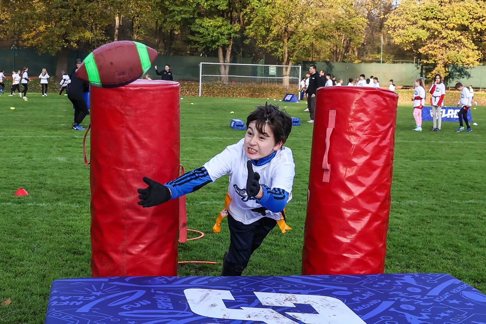 Ein Kind läuft beim NFL Flag Football in München auf gepolsterte Pylonen zu.